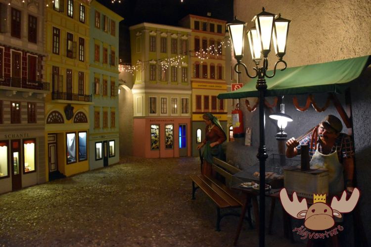 Der "Würstlmann" versucht seine Würste am Miniaturhauptplatz von Linz zu verkaufen. In der Märchenwelt wurde der Linzer Hauptplatz um 1900 in verkleinerter Form nachgebildet. - The "Würstlmann" (Sausage Seller) tries to sell his sausages on the miniature main square in Linz. In the fairy tale world, Linz's main square was reproduced in a reduced form around 1900.