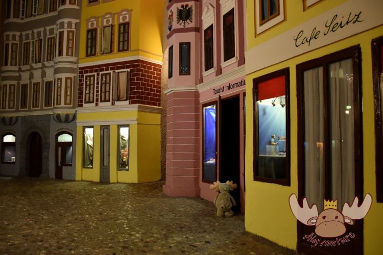 Älgbert sucht Informationen in der Miniatur-Touristeninformation. Bei der großen Version am richtigen Linzer Hauptplatz ist er erfoglreicher gewesen. - Älgbert looks for information in the miniature tourist information. He was more successful in the large version on the real Linz main square.