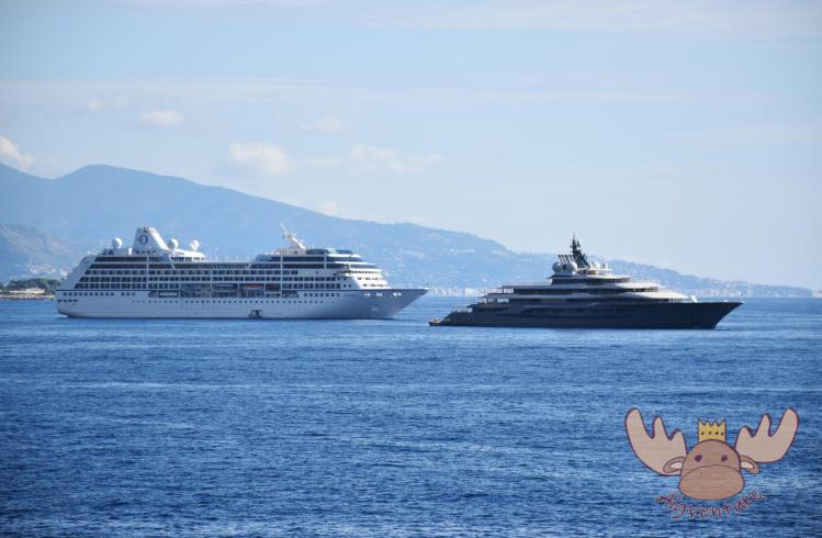 Ein kleines Kreuzfahrtschiff neben einer handelsüblichen Yacht im Hafen von Monaco. - A small cruise ship next to a commercial yacht in the port of Monaco.