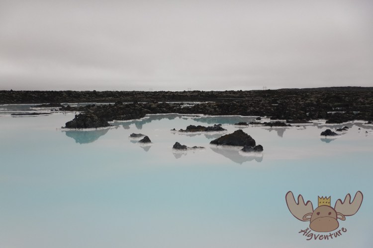 Bláa Lónið | Der Kontrast zwischen den schwarzen Vulkansteinen und dem milchig-blauen Wasser wirkt wie von einer anderen Welt. - The contrast between the black volcanic stones and the milky blue water looks like it comes from another world.