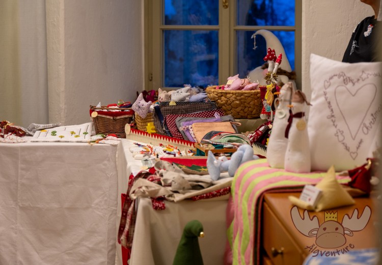 Selbstgenähte Produkte finden beim stimmungsvollen Weihnachtsmarkt auf Schloss Weinberg neue Besitzer:innen. - Homemade products find new owners at the atmospheric Christmas market at Weinberg Castle.
